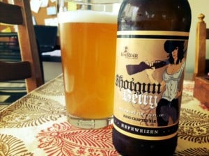Pint of beer next to a bottle of Shotgun Betty on a table.