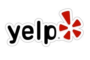 Yelp logo with black text and a red flower shape.